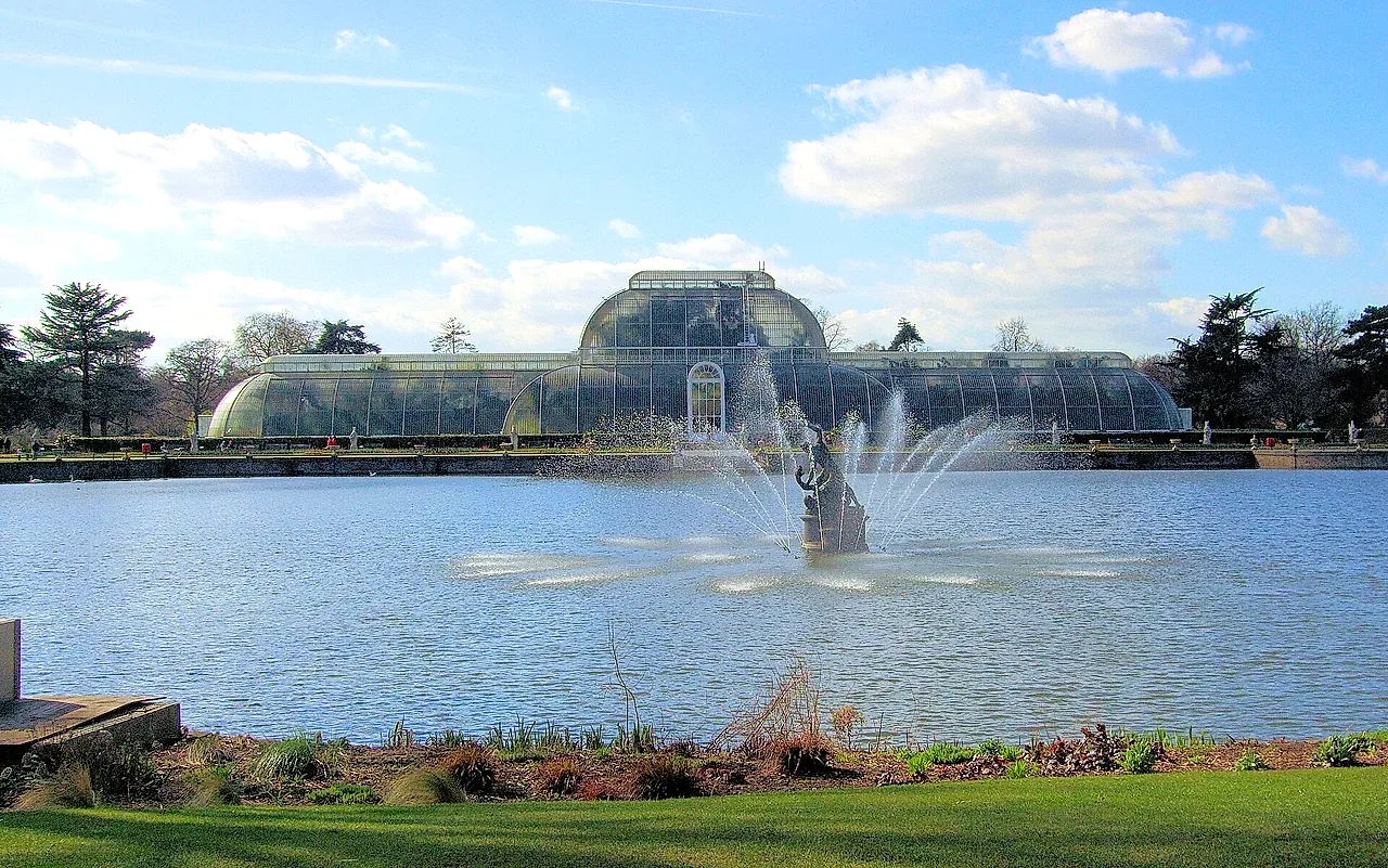 La Palm House oltre il lago, con la fontana che zampilla sull'acqua in primo piano
